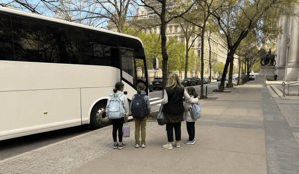 school field trip group unloading from a charter bus near the american museum of natural history in new york city