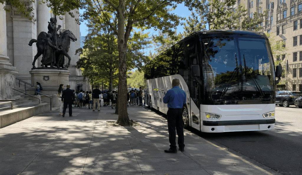 charter bus parked after an amnh field trip drop-off with lunch coolers and backpacks stored in the luggage bay