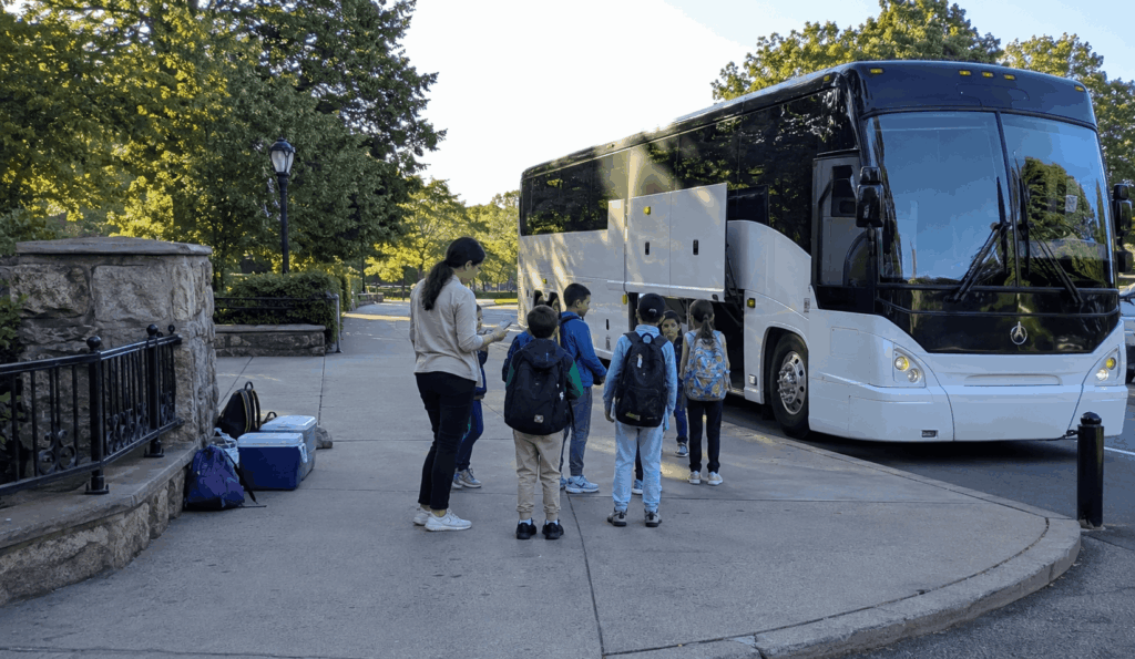 charter bus dropping off a school group near the bronx zoo for a class field trip