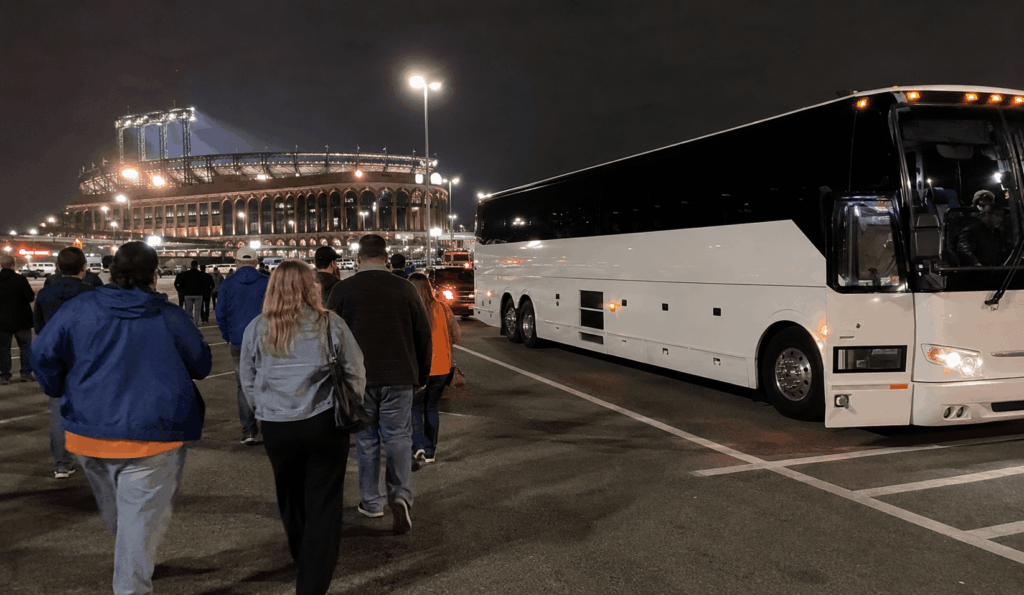 charter bus waiting in the citi field parking area for postgame pickup after a night event