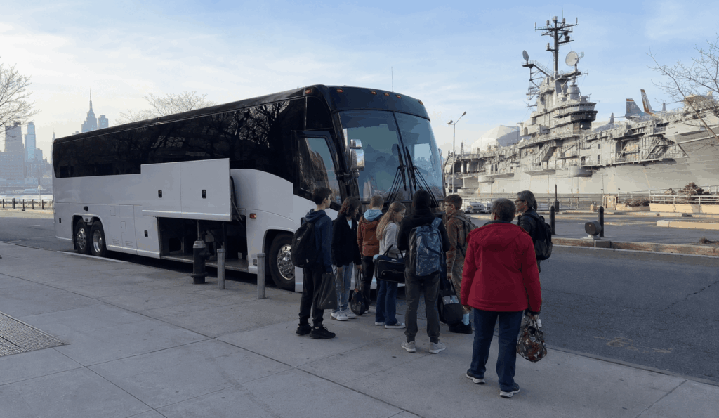 charter bus dropping off students and chaperones near the intrepid sea air and space museum at pier 86 in manhattan