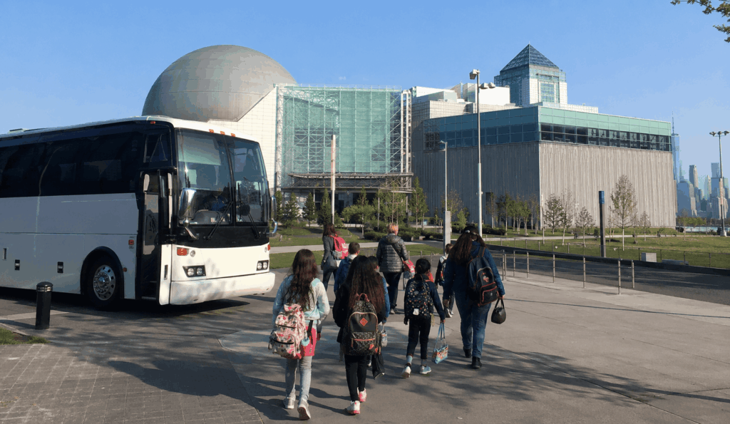charter bus dropping off a school group at liberty science center in jersey city for a field trip