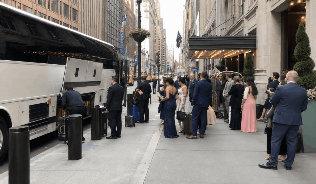 wedding guests arriving by charter bus at a waterfront warehouse wedding venue in red hook brooklyn