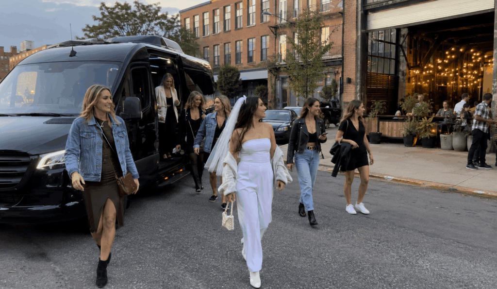 bachelorette group stepping off a party bus near a manhattan rooftop lounge entrance during an evening nyc itinerary