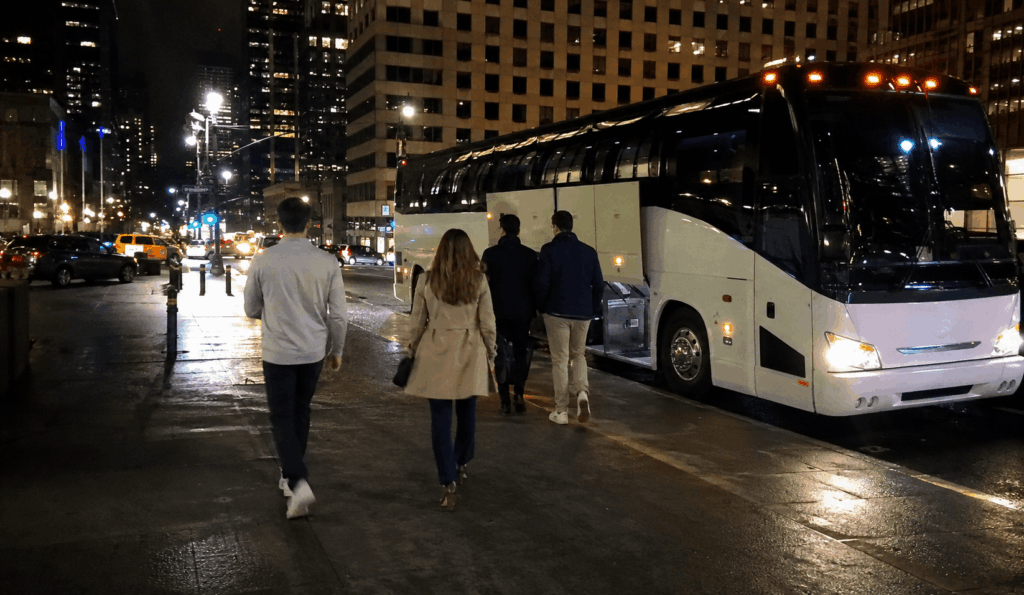 corporate and alumni event guests boarding a charter bus outside a midtown manhattan hotel before an msg event