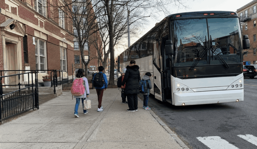charter bus picking up students and chaperones outside a new york city school for a field trip