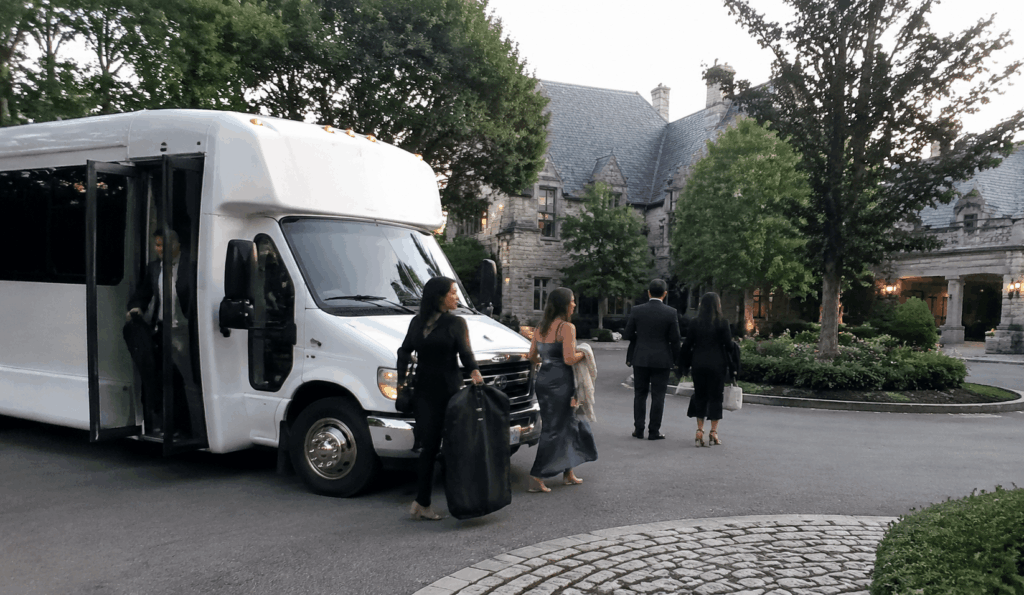 wedding shuttle bus arriving at a new jersey chateau venue with guests stepping off near the estate driveway