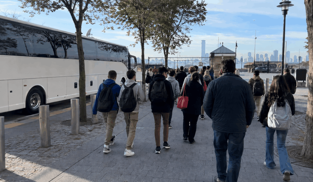 charter bus dropping off a school group near the battery park ferry departure area for a statue of liberty and ellis island field trip in lower manhattan