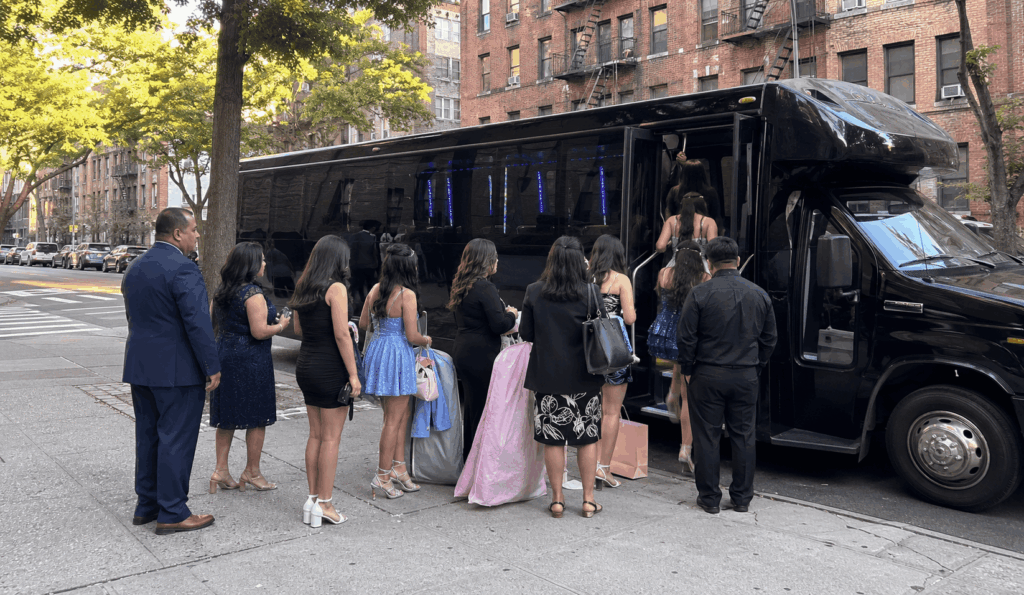 party bus picking up a sweet 16 or quinceañera group on a new york city curb before a milestone birthday celebration